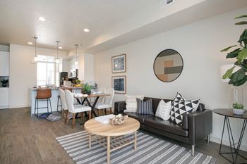 A modern living room with a brown couch and a wooden coffee table.